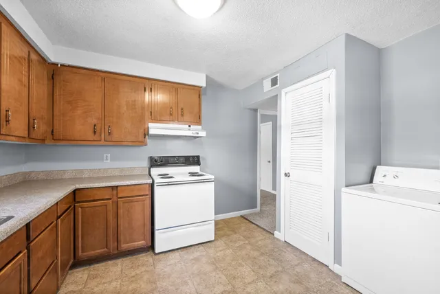 a kitchen with a stove top oven sink and cabinets
