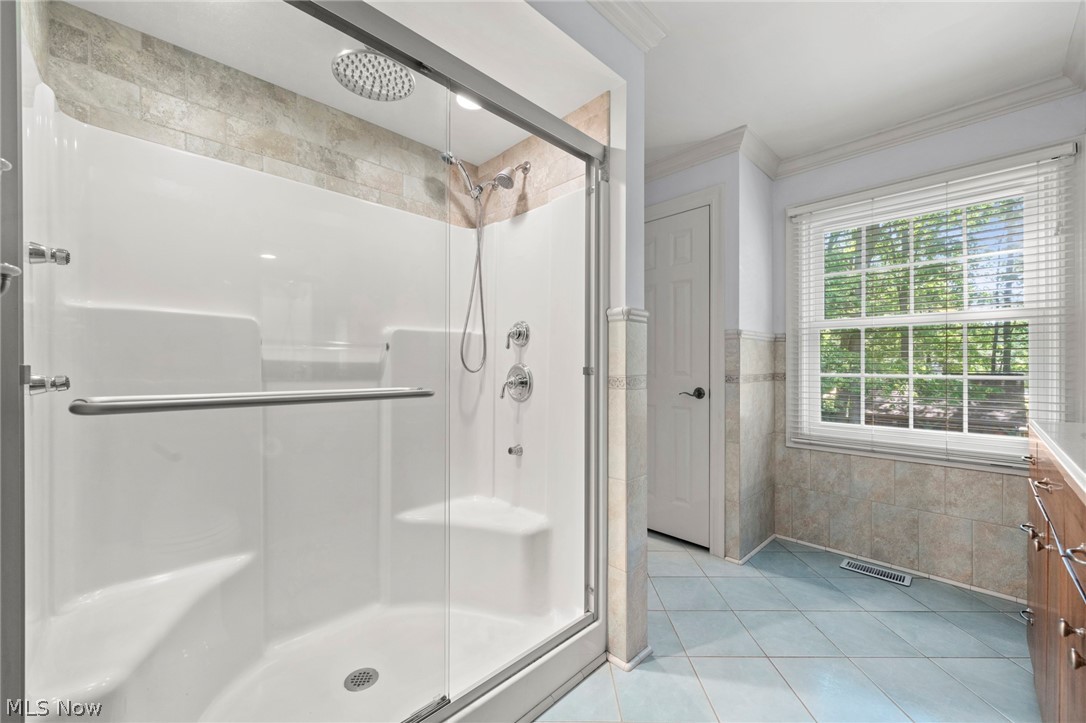 3871 Greentree Road Stow, OH 44224 - Photo 22 of 50 Spacious shower enclosure with glass doors, built-in seating, rainfall showerhead, and a handheld shower fixture