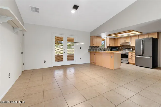 a kitchen with stainless steel appliances granite countertop a refrigerator and a stove top oven