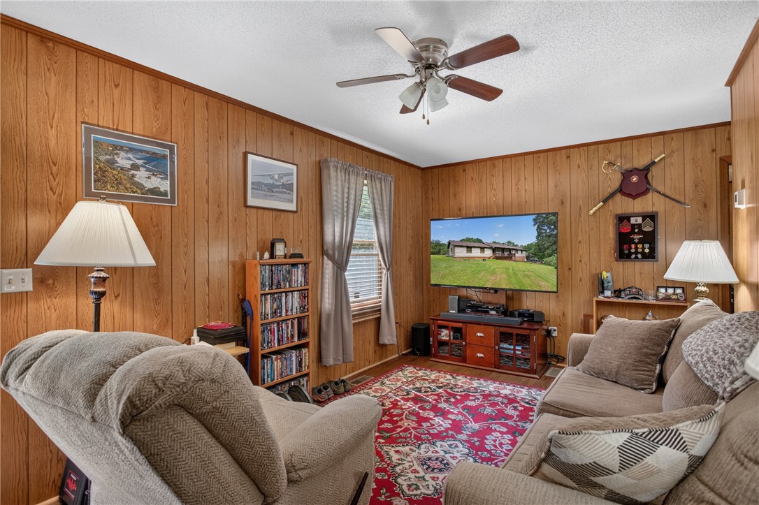 120 Coneross Knob Drive Seneca, SC 29678 - Photo 29 of 37 In-law suite living room featuring wood paneling and an overhead ceiling fan.