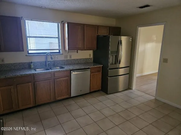 a kitchen with stainless steel appliances granite countertop a refrigerator and a sink
