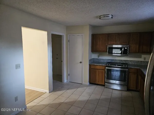 a kitchen with stainless steel appliances granite countertop a stove a microwave and a refrigerator