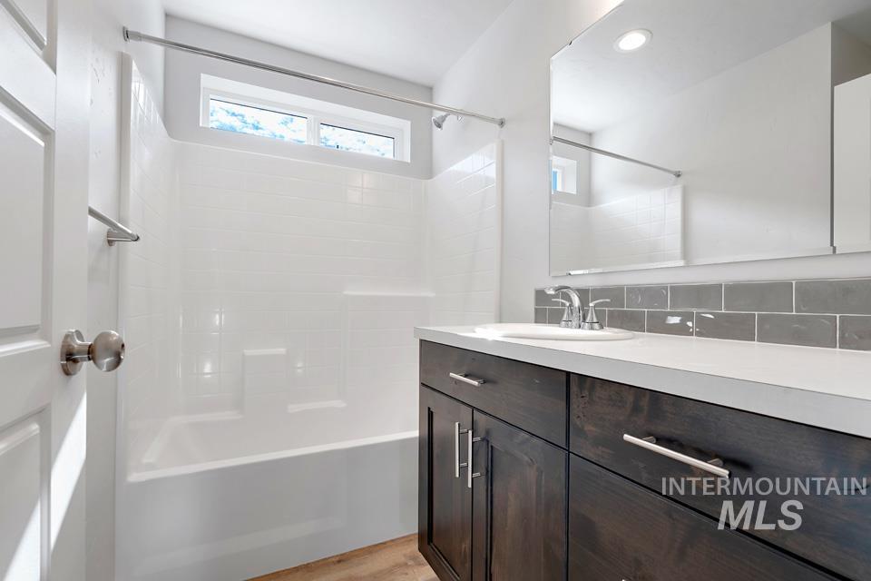 1340 Dawn Street Weiser, ID 83672 - Photo 24 of 32 Full bath with vanity, shower / bathtub combination, backsplash, and light wood-style floors