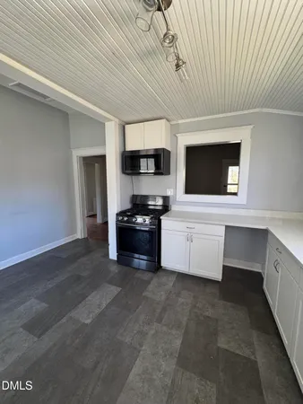 an empty room with wooden floor and a rug