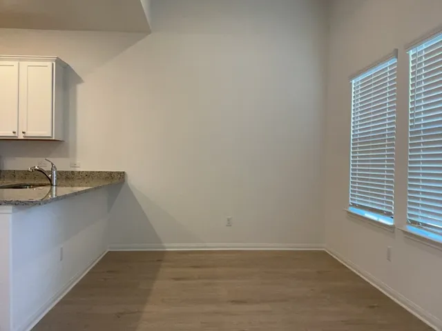 a kitchen with stainless steel appliances granite countertop white cabinets a microwave oven and a sink