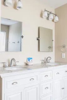 a bathroom with double sink and a mirror
