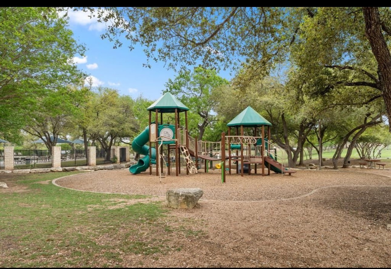 3704 Caney Creek Road Austin, TX 78732 - Photo 36 of 38 a view of a park with swings and slides