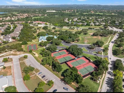 an aerial view of residential houses with outdoor space and trees