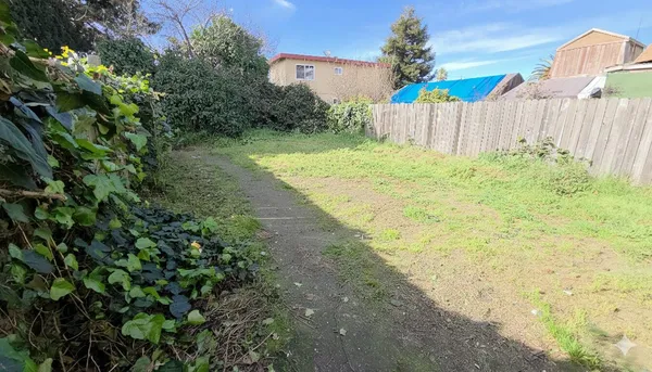 a view of a backyard with wooden fence