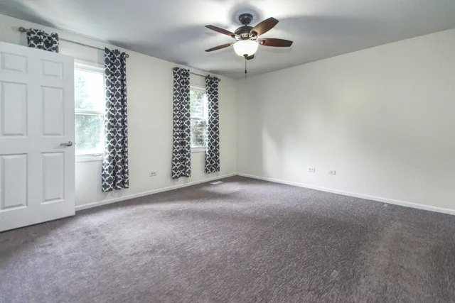 a view of empty room with ceiling fan