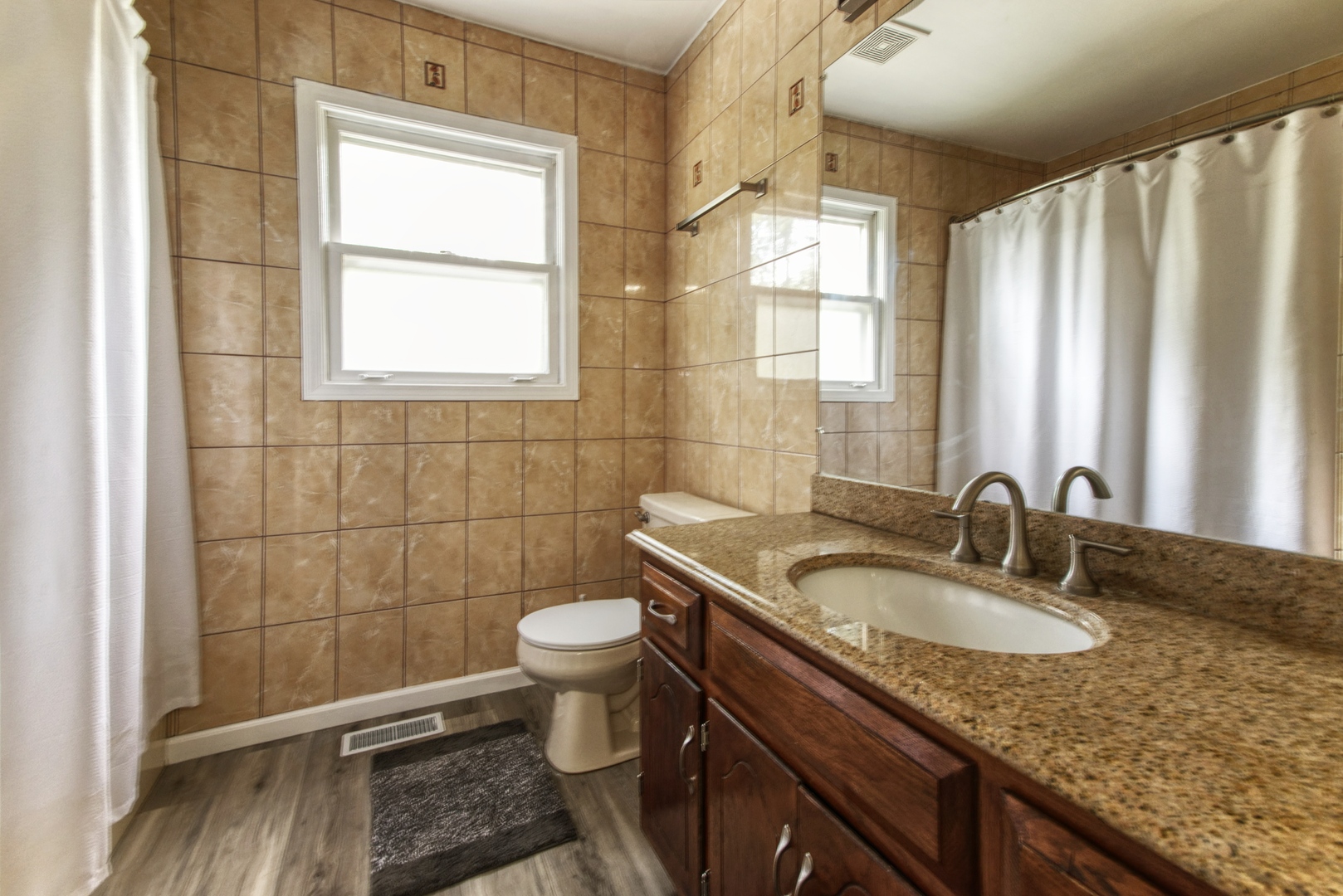 2312 Verdun Drive Joliet, IL 60435 - Photo 16 of 24 a bathroom with a granite countertop sink a toilet and a window