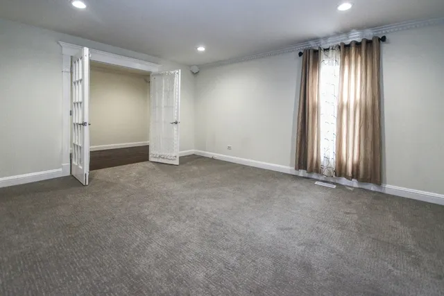 an empty room with windows and closet