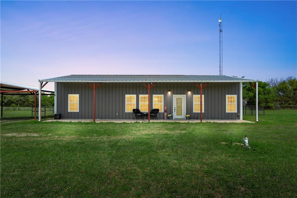 a front view of house with yard barbeque and outdoor seating