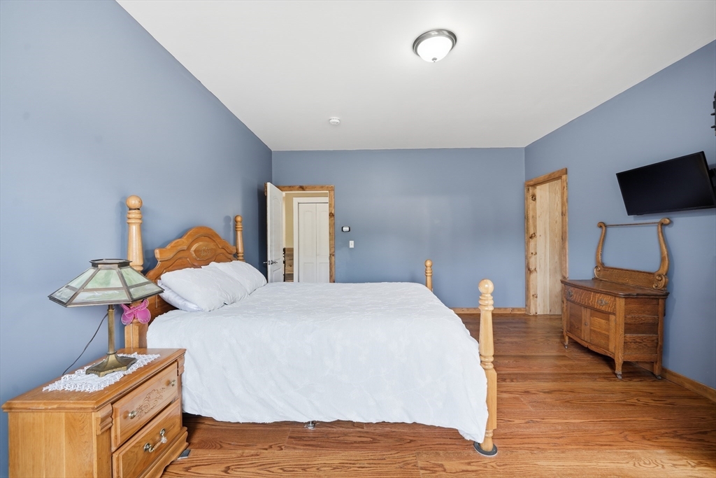 96 Stafford Hollow Road Monson, MA 01057 - Photo 19 of 39 a bedroom with a bed and wooden floor