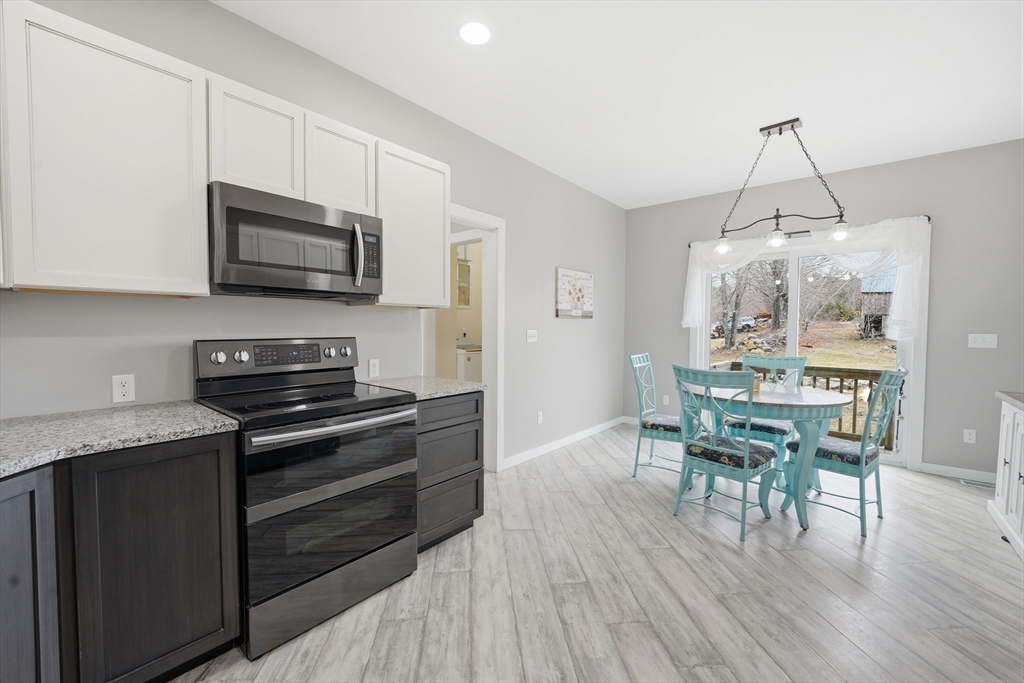96 Stafford Hollow Road Monson, MA 01057 - Photo 6 of 39 a kitchen with stainless steel appliances a kitchen island hardwood floor sink stove dining table and chairs