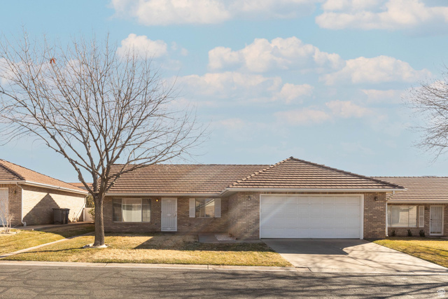 1090 East 700 South, Unit 20 St. George, UT 84790 - Photo 1 of 1 Ranch-style house with a tile roof, a front yard, a garage, brick siding, and driveway
