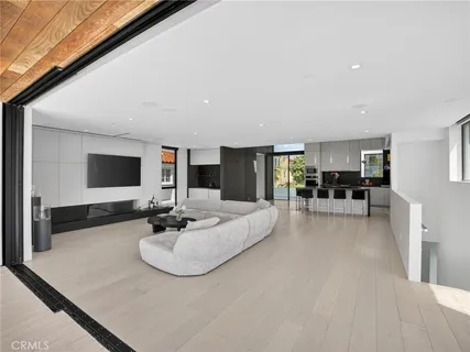 a living room with couch a large window and a flat screen tv