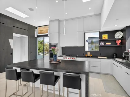 a kitchen with stainless steel appliances granite countertop a sink and a refrigerator