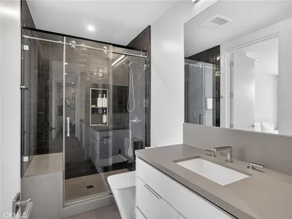 a bathroom with a granite countertop sink mirror shower and toilet