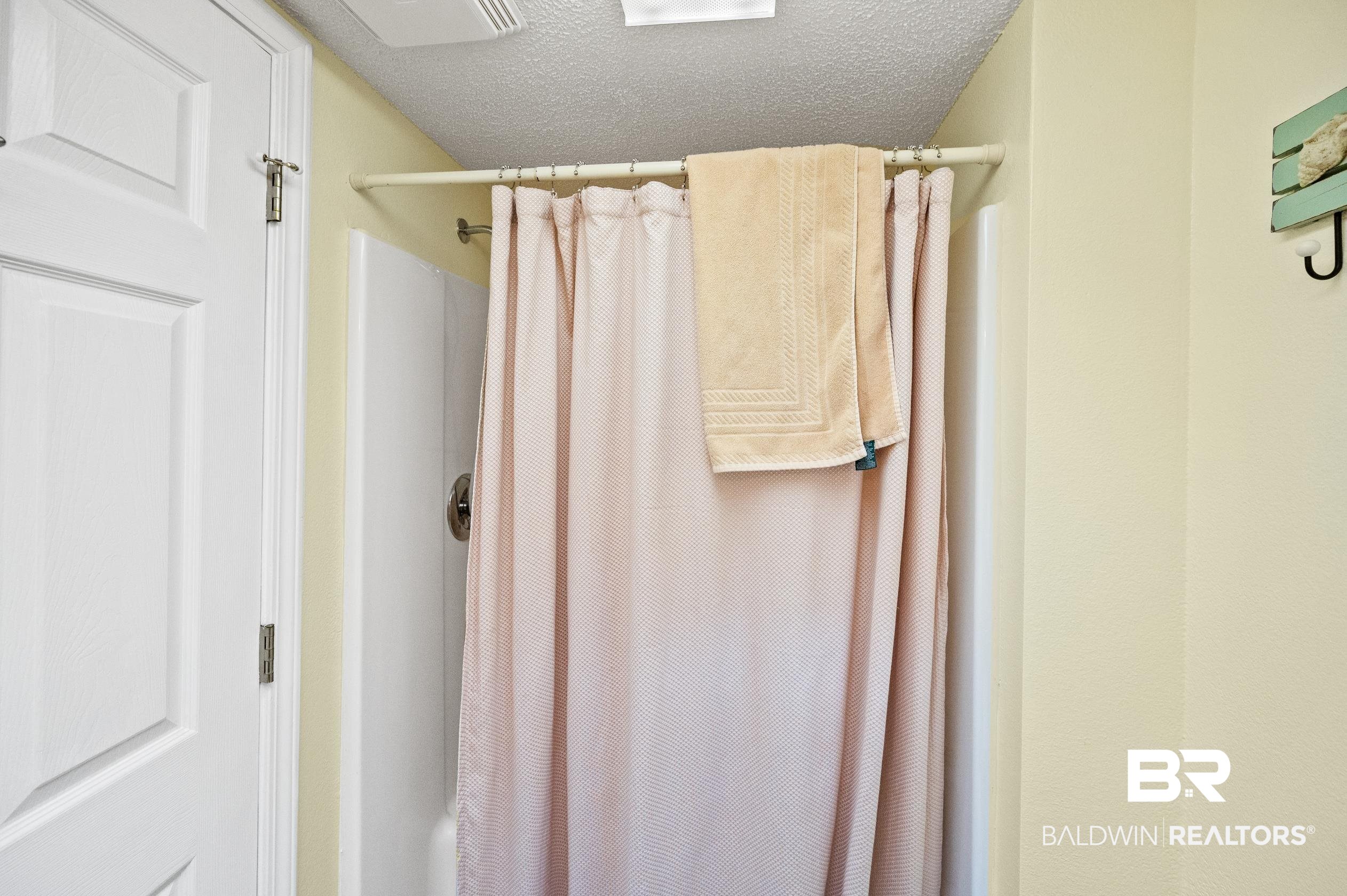 5392 Ornacor Avenue Orange Beach, AL 36561 - Photo 21 of 48 Bathroom featuring shower / bathtub combination with curtain and a textured ceiling
