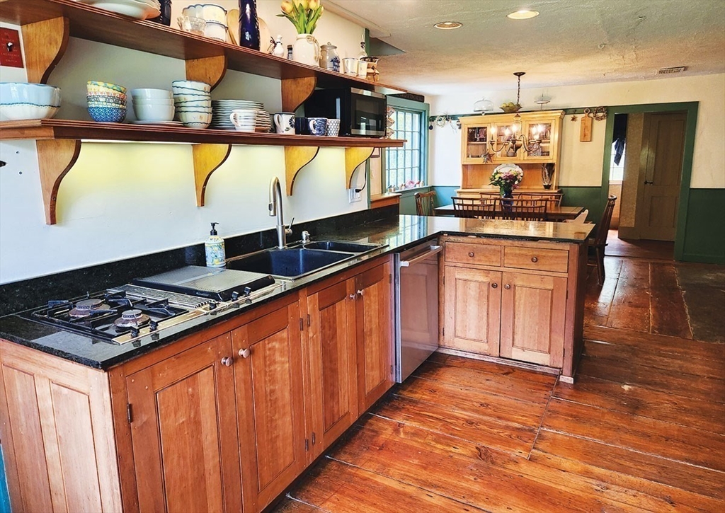 164 Worcester Road Westminster, MA 01473 - Photo 11 of 39 a kitchen with stainless steel appliances granite countertop a stove a sink dishwasher and a microwave oven with large wooden cabinets