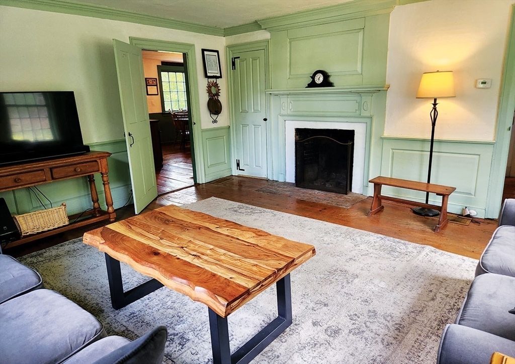 164 Worcester Road Westminster, MA 01473 - Photo 7 of 39 a living room with a table a fireplace and a flat screen tv