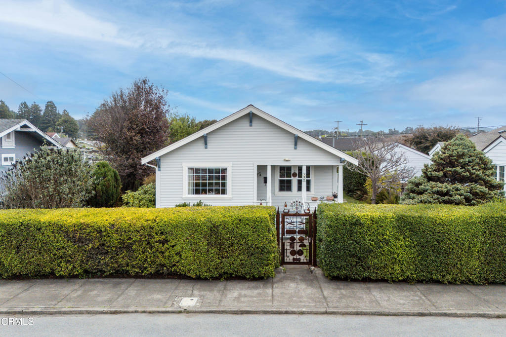 a view of a house with a yard and potted plants