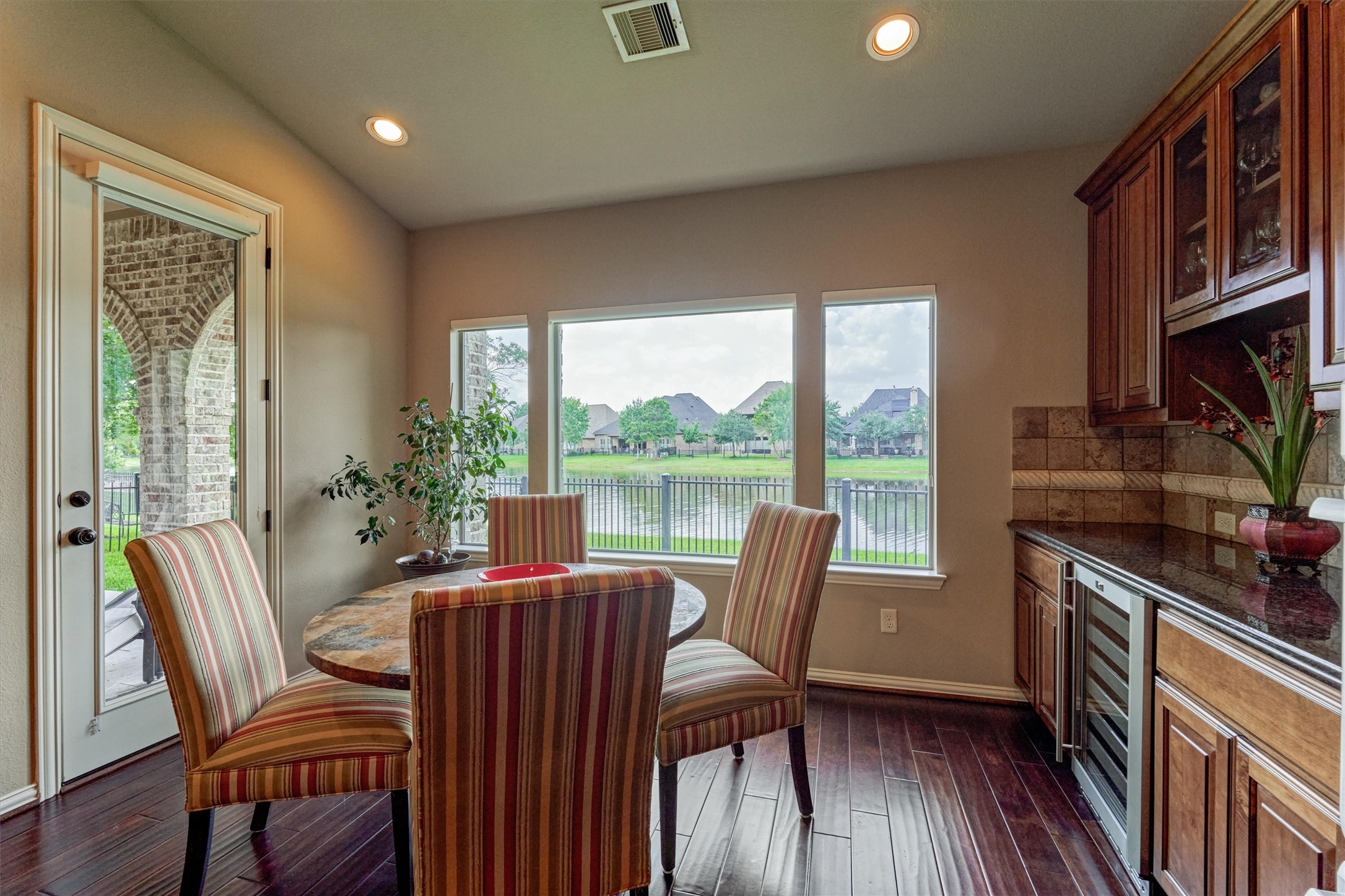 82 East Crystal Canyon Circle The Woodlands, TX 77389 - Photo 12 of 50 The sunny breakfast room stuns with picturesque views and features a dry bar with additional storage, prep space, and a wine fridge.