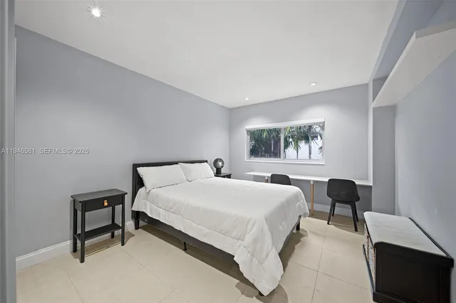 a bedroom with a bed lamp and a window