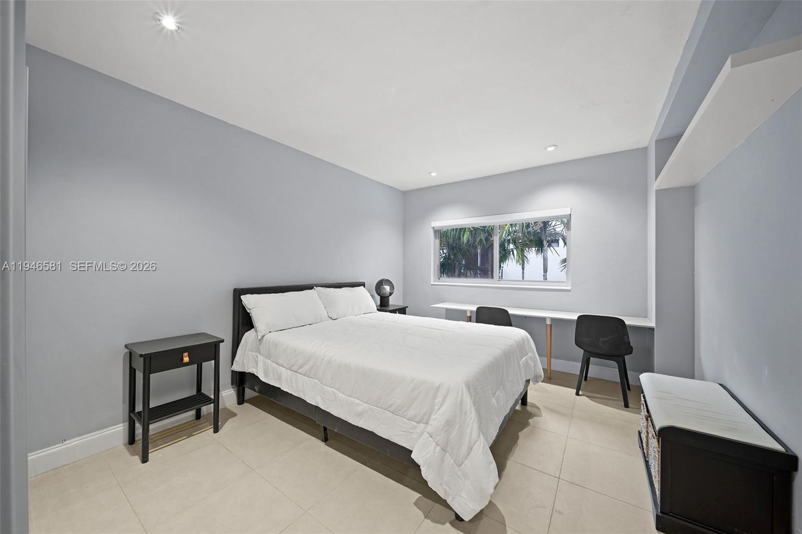 1145 101st Street, Unit 4 Bay Harbor Islands, FL 33154 - Photo 17 of 22 a bedroom with a bed lamp and a window