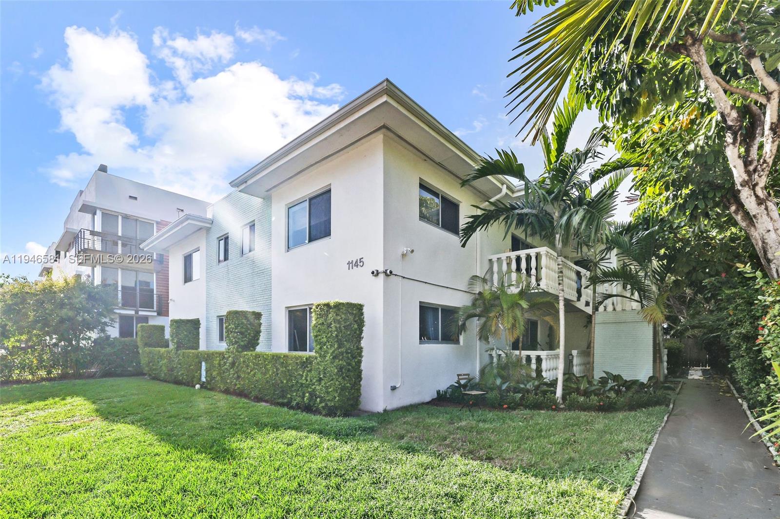 1145 101st Street, Unit 4 Bay Harbor Islands, FL 33154 - Photo 19 of 22 a view of a white house with a big yard and large trees