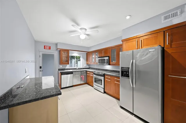 a large kitchen with stainless steel appliances granite countertop a refrigerator a oven a sink and dishwasher