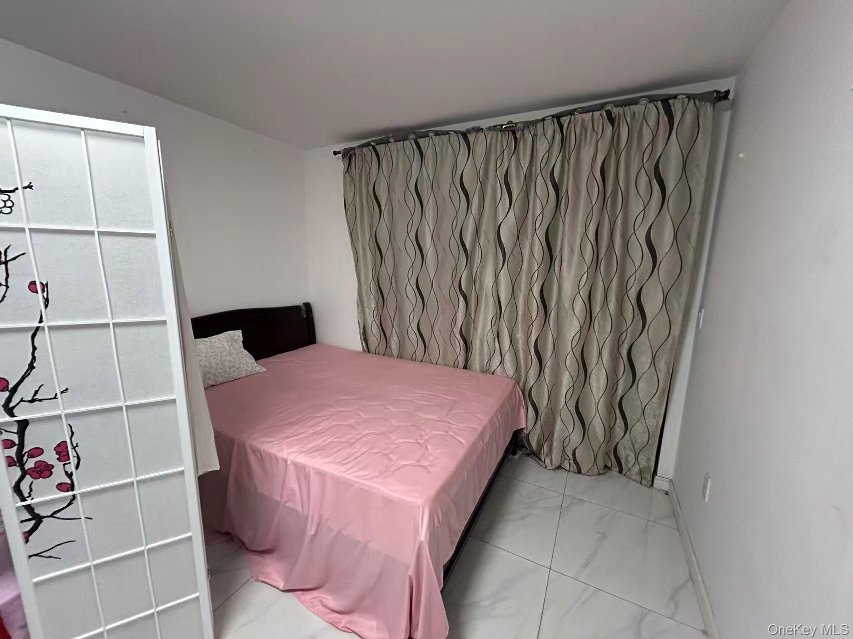 132-16 Maple Avenue, Unit 3A Queens, NY 11355 - Photo 6 of 10 a bedroom with a bed and a cabinets