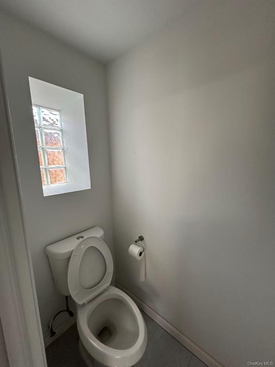 132-16 Maple Avenue, Unit 3A Queens, NY 11355 - Photo 7 of 10 a toilet sitting in a bathroom next to a wooden wall