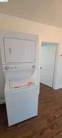 a utility room with wooden floor washer and dryer