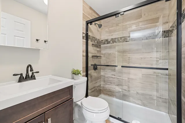 a bathroom with a sink a toilet and shower