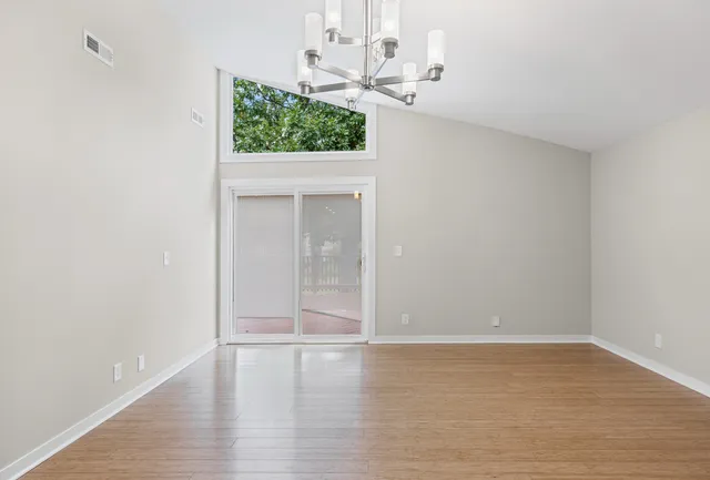 a view of a room with wooden floor and chandelier