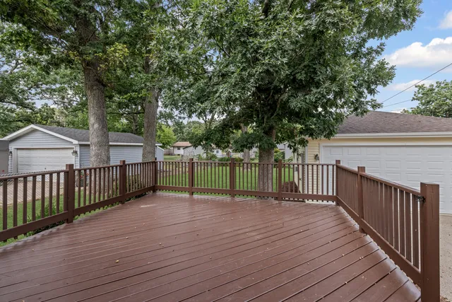 a view of a deck with a large trees and wooden fence