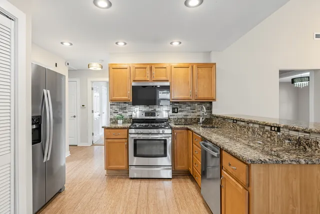 a kitchen with stainless steel appliances granite countertop a stove and a refrigerator