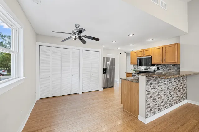 a kitchen with stainless steel appliances kitchen island granite countertop a refrigerator and a stove top oven