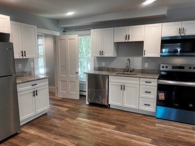 a kitchen with stainless steel appliances granite countertop a stove a sink and a refrigerator