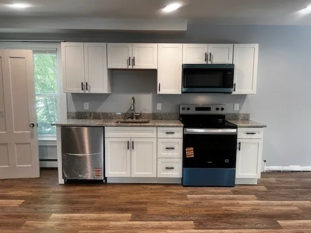 a kitchen with stainless steel appliances a stove a sink and a microwave