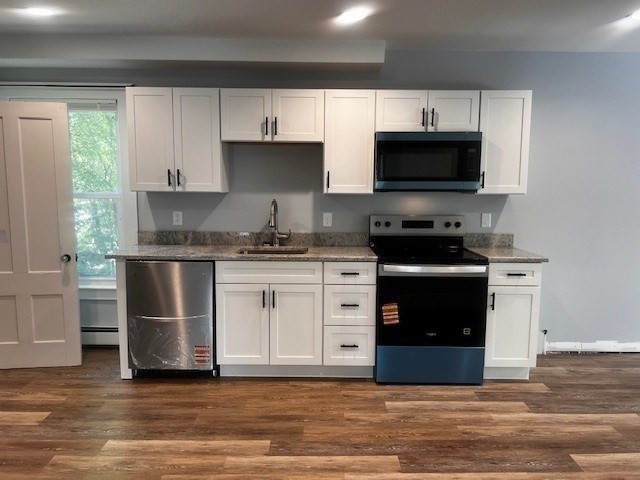 1 Madison Street, Unit B Amesbury, MA 01913 - Photo 2 of 17 a kitchen with stainless steel appliances a stove a sink and a microwave