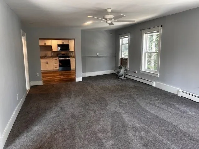 an empty room with windows and cabinet