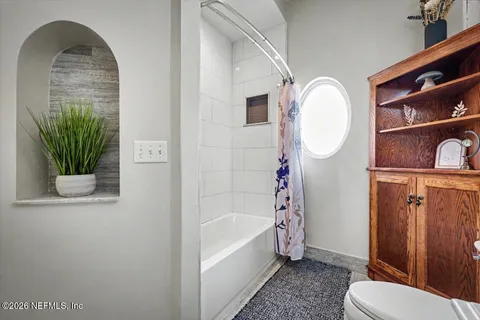 a bedroom with a bed a ceiling fan and a dresser