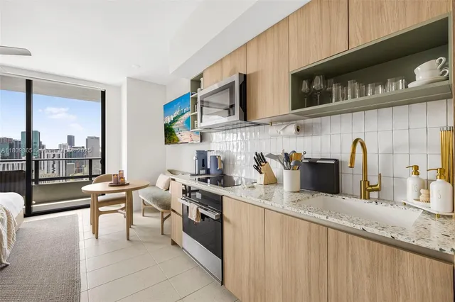 a kitchen with stainless steel appliances granite countertop a refrigerator and a stove top oven