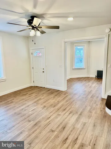 a view of empty room with wooden floor
