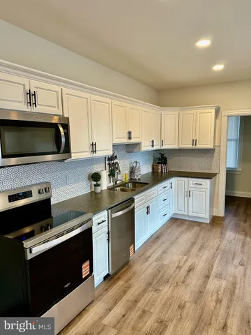 a kitchen with stainless steel appliances granite countertop a stove a sink and a microwave