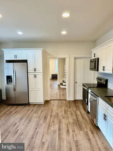 a kitchen with granite countertop a refrigerator and a sink