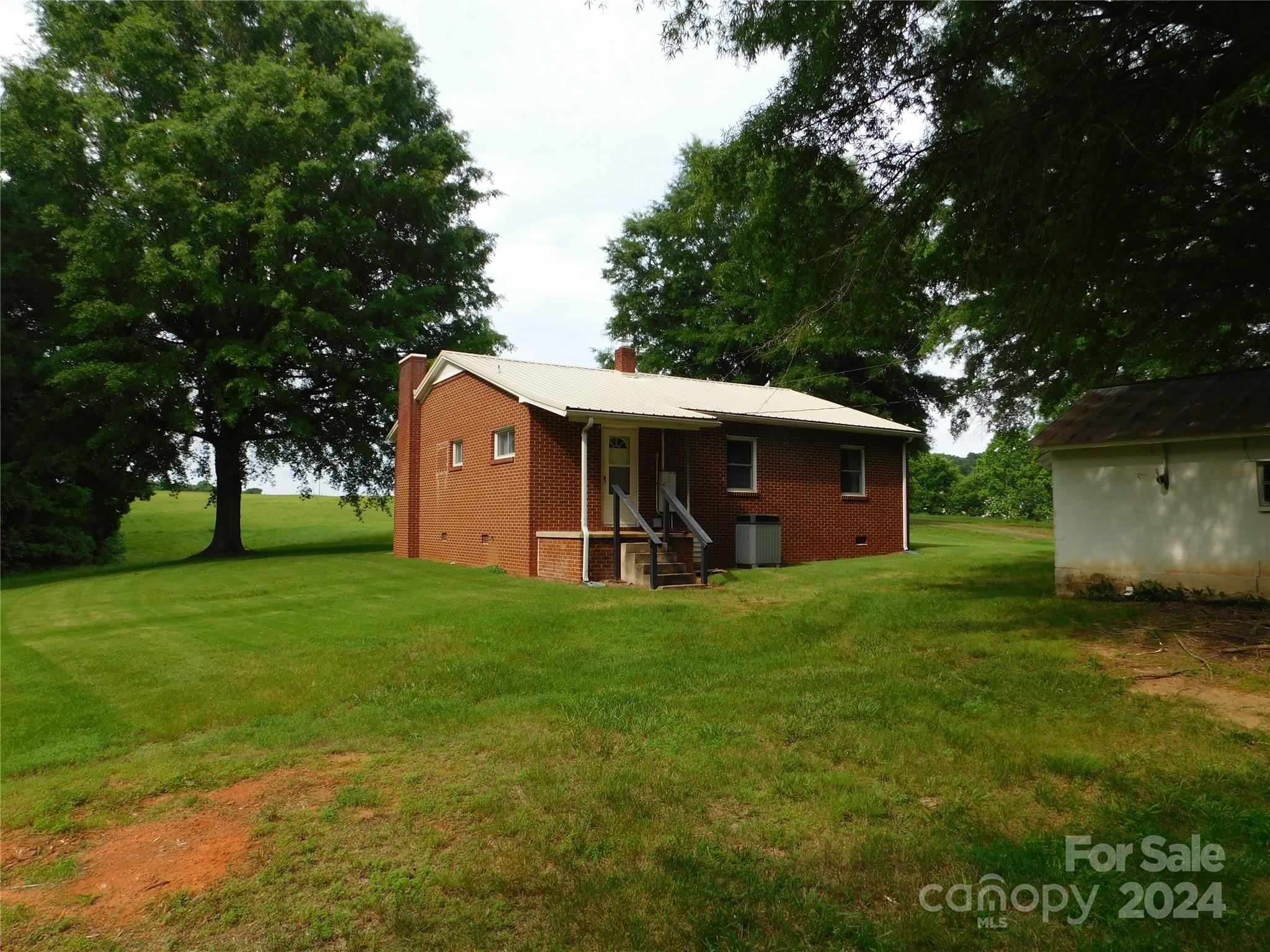 175 Fairmount Road Statesville, NC 28625 - Photo 12 of 30 a view of a backyard with table and chairs and a large tree